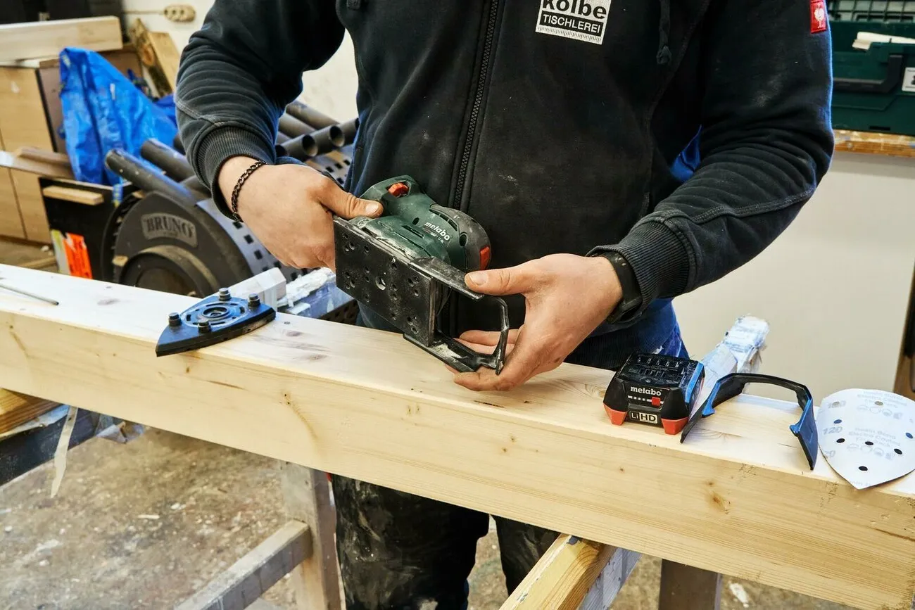 Handwerker schiebt den Protektur zum Schutz umliegender Kanten auf.